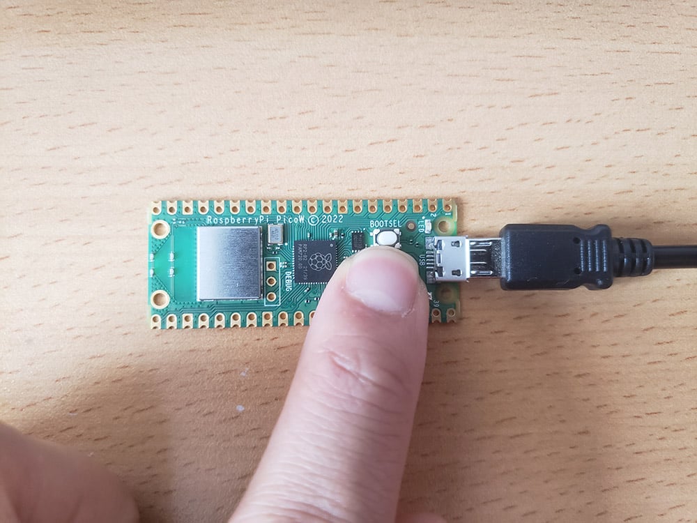 Mantenga pulsado el botón BOOTSEL, luego conecte su USB en la Raspberry Pi Pico W.